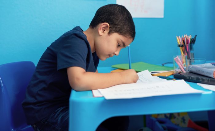 Writing, notebooks and child with homework in house for education, learning or development with knowledge. Scholarship, kid and boy student studying mathematics for school assignment in apartment.